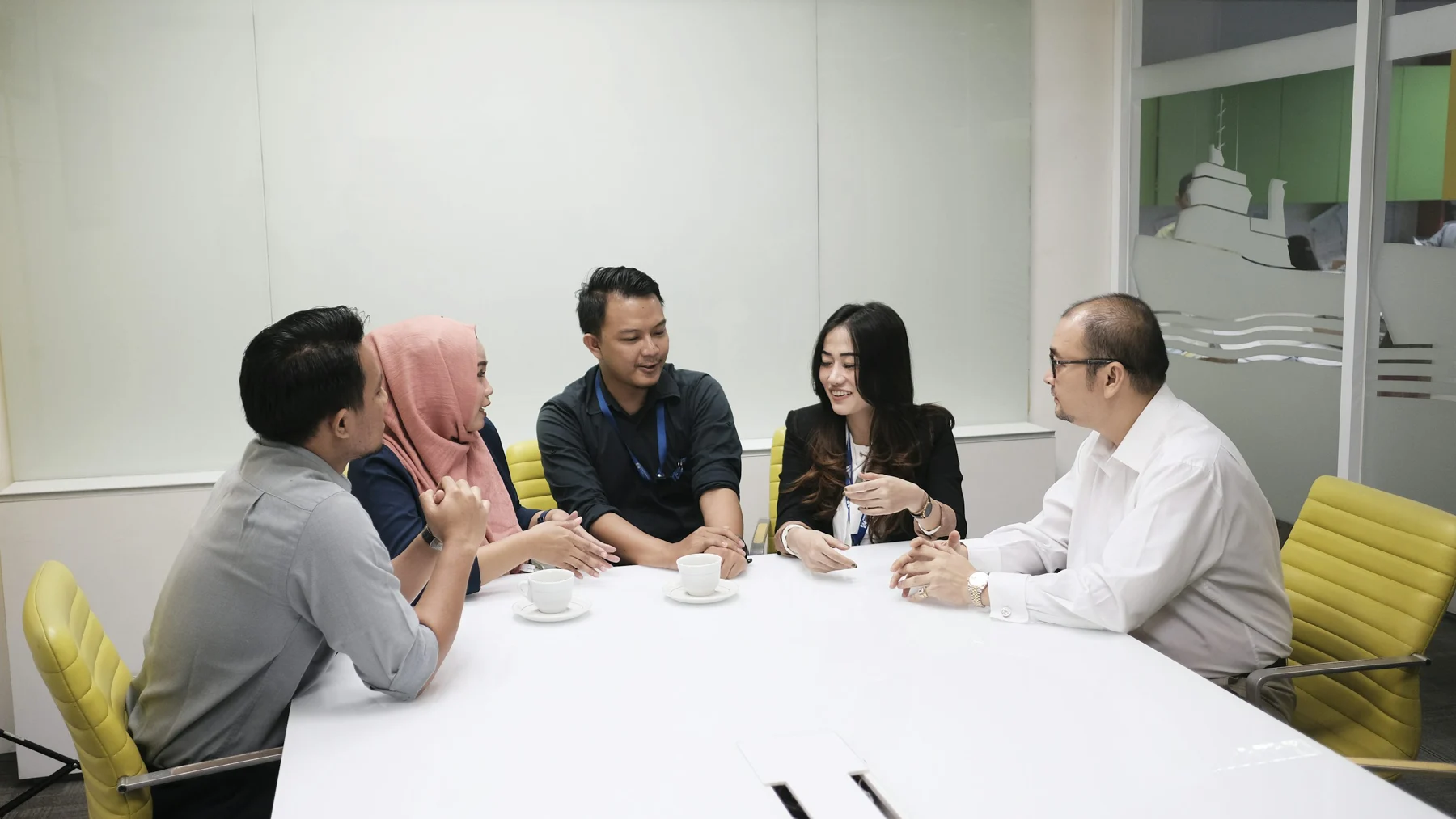 Asian business professionals discussing their plans around a meeting table